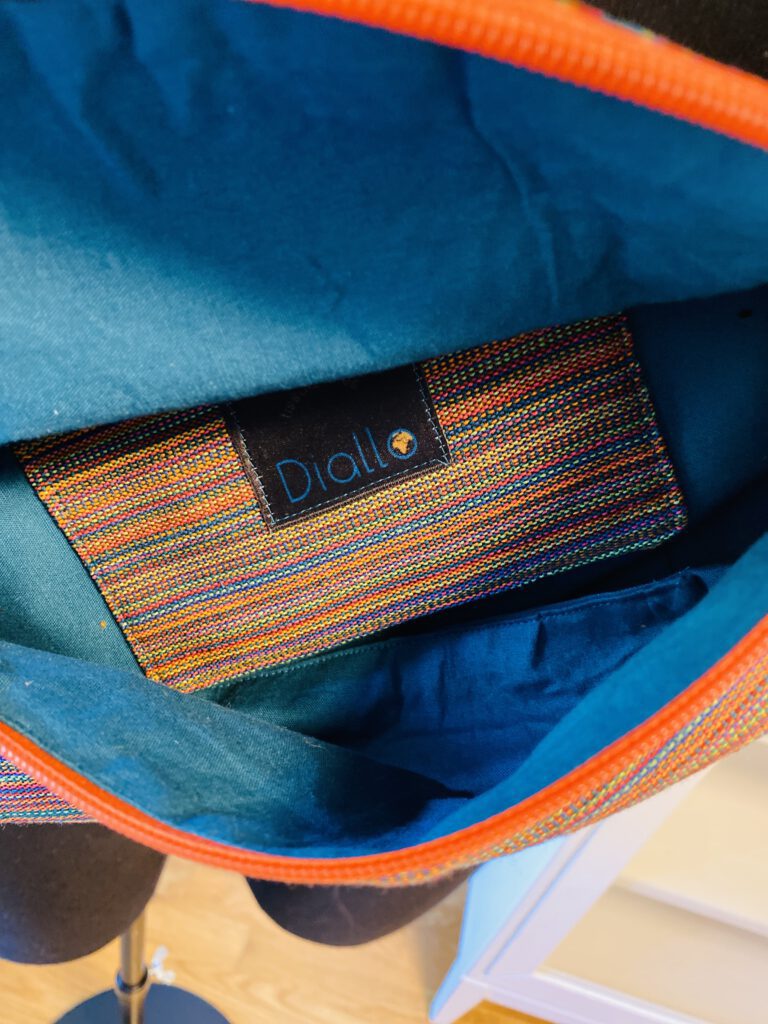 Die Regenbogen-Tasche von innen mit petrolfarbenem Futter und Innentasche