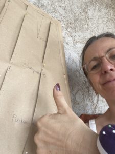 Graded paper pattern and designer lifting her thumb up