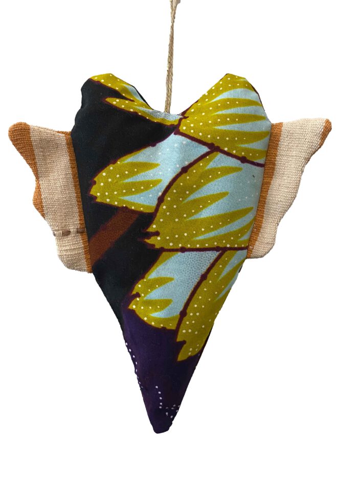 Handgenähtes Herz aus bunt gemustertem Waxprint-Stoff mit großem gelbem Blattmotiv auf dunklem Grund, naturfarbene Flügel aus Faso dan Fani aufgehängt an einer Hanfkordel mit Goldakzent.