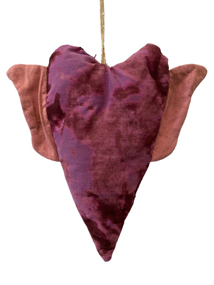 Handgemachtes Herz aus violett-pinkem Batikstoff mit weichrosa Flügeln, aufgehängt an einer naturfarbenen Kordel.